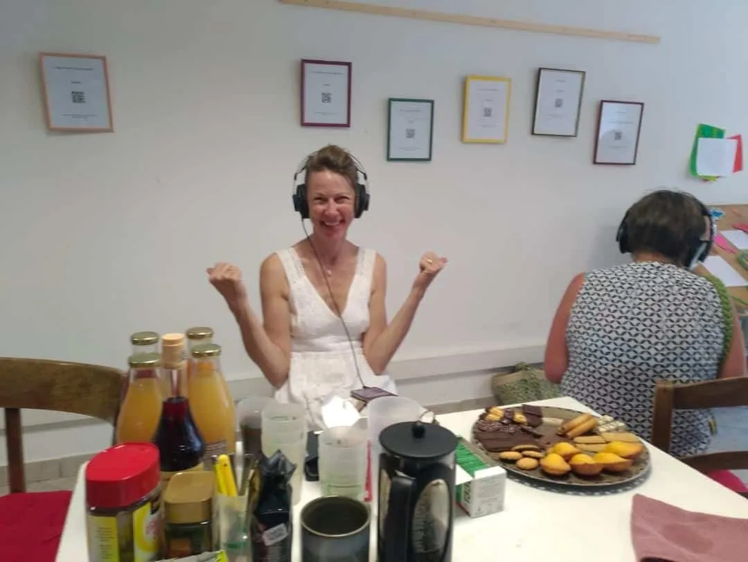 Une participante, casque sur les oreilles, lève les bras en souriant