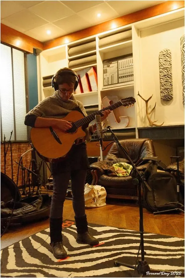 La guitariste du groupe, casque sur les oreilles, pendant l’enregistrement