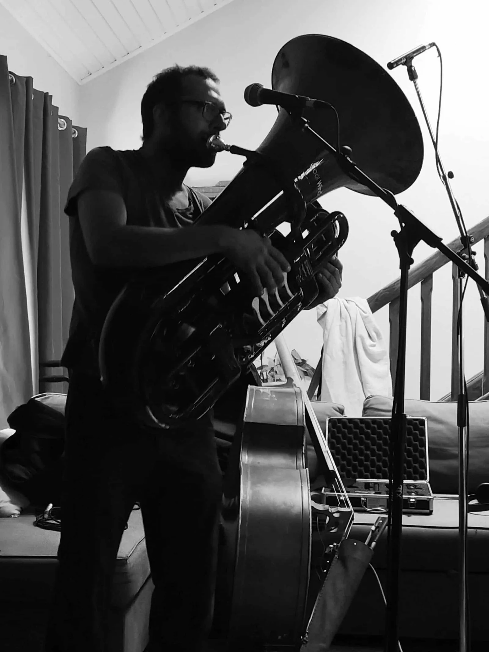Un musicien joue du tuba devant un micro